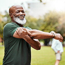 man stretching his arms outdoors