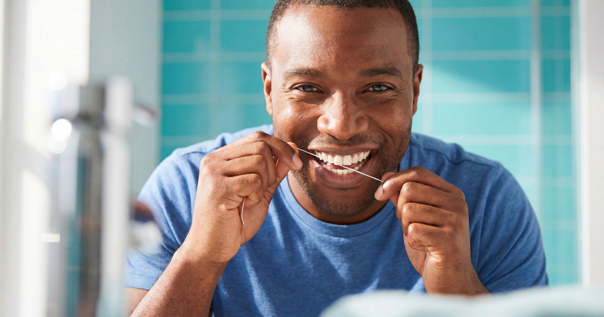man smiling and flossing