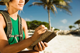 Woman sitting on the beach journaling