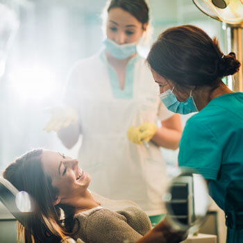 woman smiling and talking to dental hygienists