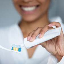 Woman putting toothpaste on brush