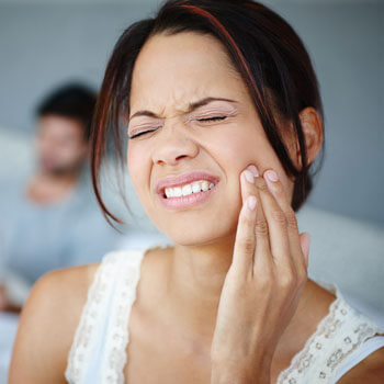 woman holding jaw in pain