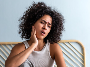 woman holding jaw with pain