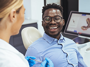 man sitting in dentists chair smiling
