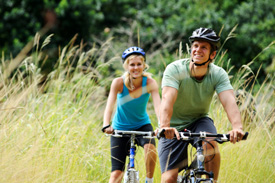 Couple biking thru a field