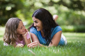 Mom and daughter laying in grass