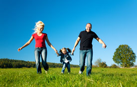 family running through grass wearing jeans