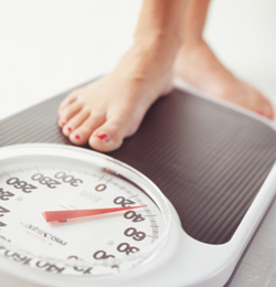 Woman stepping on scale