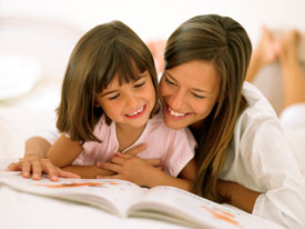 Woman and little girl looking at a book. 