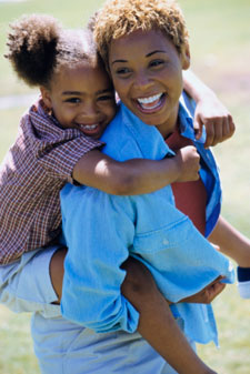 mother giving daughter piggy back ride