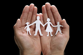 Hands holding paper cut out of family