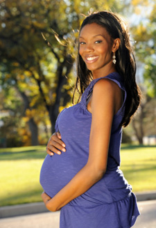 Pregnant woman holding belly and smiling