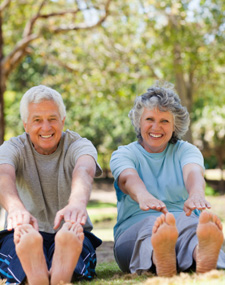 Elderly couple stretching outdoors