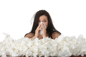 woman with flu surrounded by used tissue paper