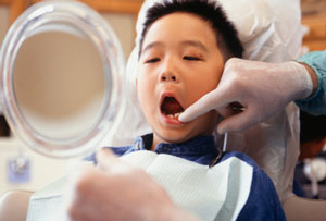 Dentist showing little boy his teeth in a mirror