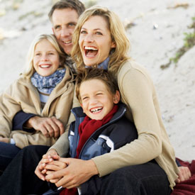 family smiling outside in fall