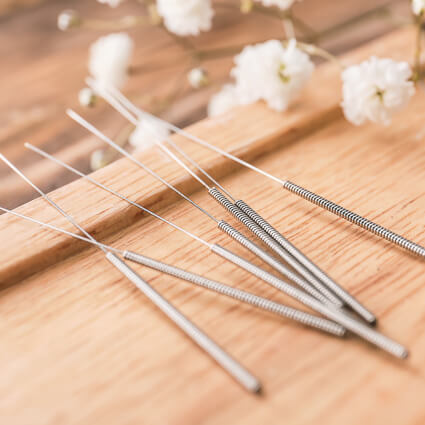 acupuncture needles on a wooden surface