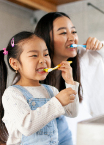 mom and daughter brushing teeth