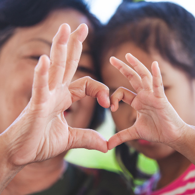 Mother and daughter making heart with hands