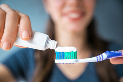 Putting toothpaste on toothbrush