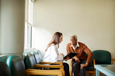 Assistant showing a patient paperwork in the waiting room