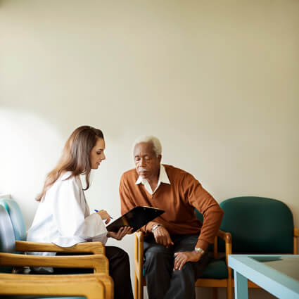 assistant showing man paperwork in waiting room