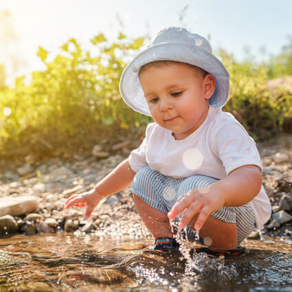 Young kid playing by a river