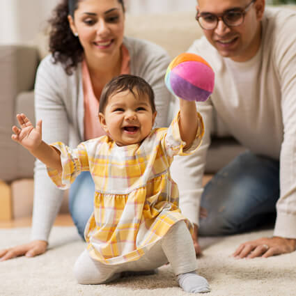 smiling mom and dad playing with baby