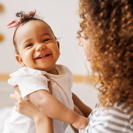 smiling baby being held by mom