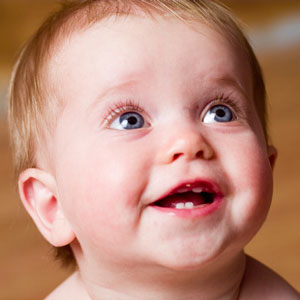 Infant looking up with baby teeth