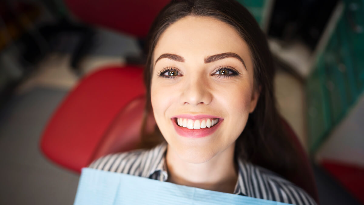 woman in dental chair with beautiful white smile