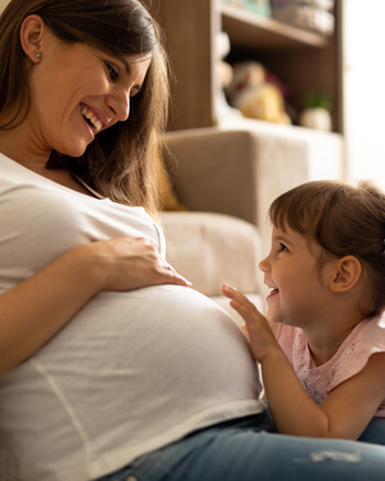 pregnant Mom and little girl smiling