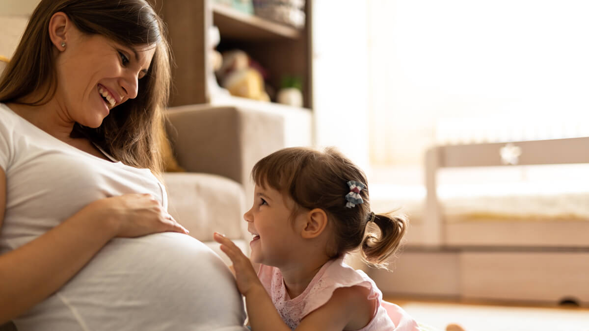 Mom and daughter touching pregnant belly