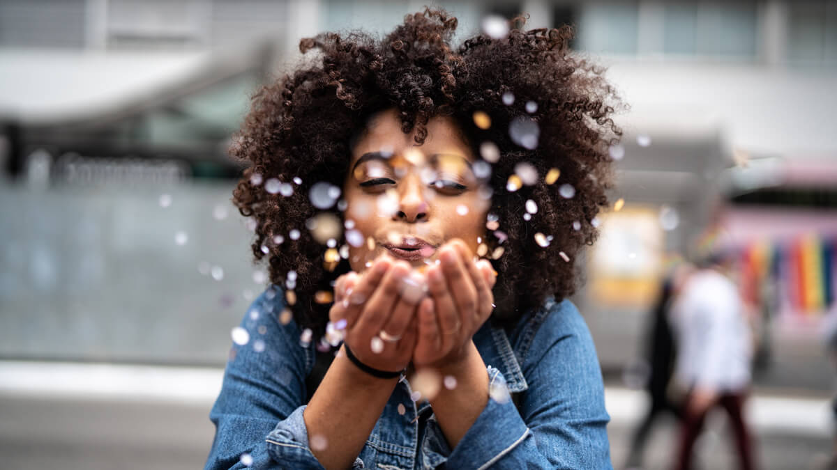 Woman blowing confetti from hands