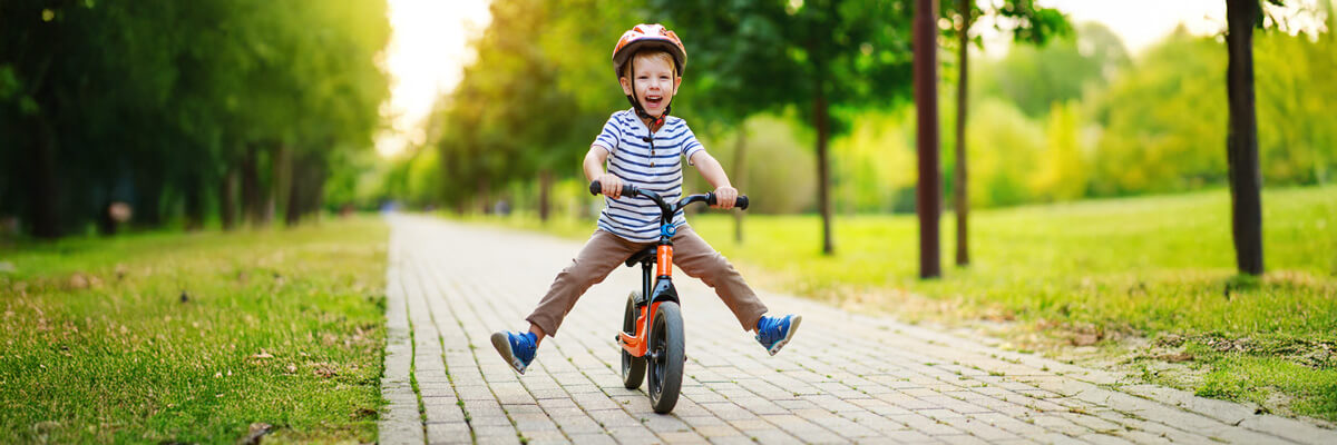 Smiling little boy riding a bicycle