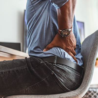 casual man with low back pain sitting