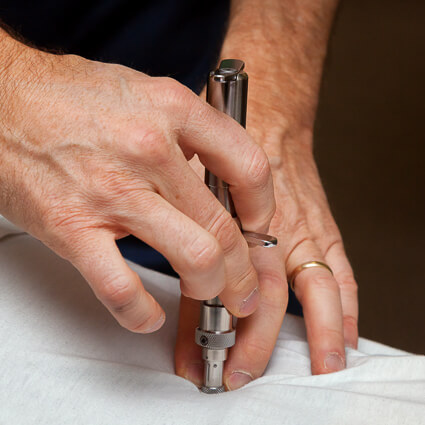 activator tool being used on persons back