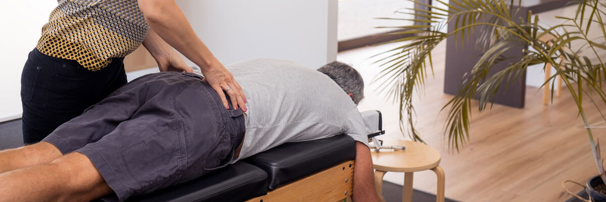 Male patient receiving a chiropractic back adjusdtment