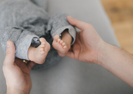 Hands on baby's legs