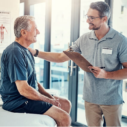 Chiropractor reassuring man on adjustment table