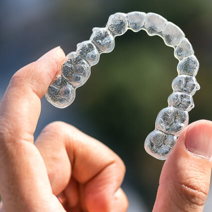 person holding a clear aligner