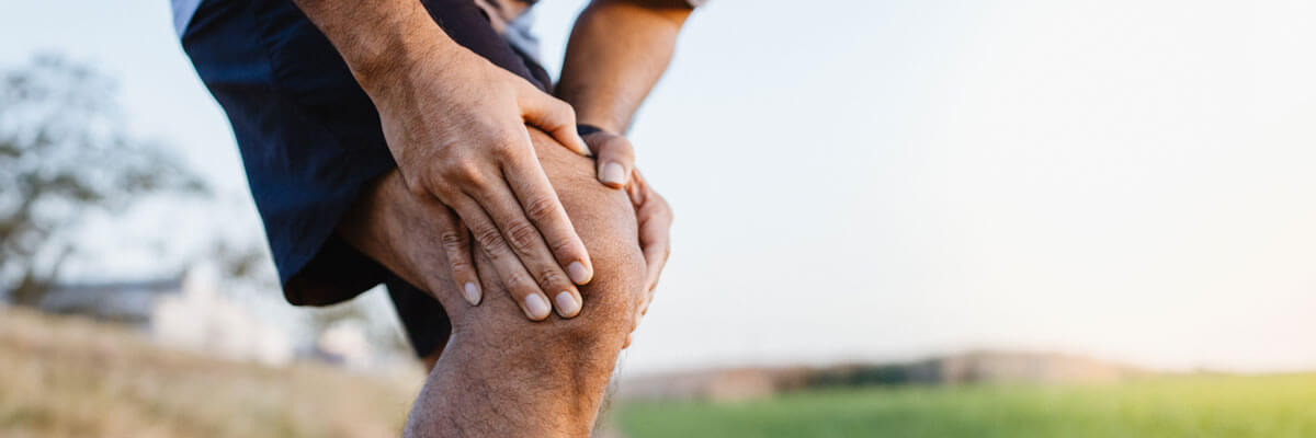 man holding knee in pain