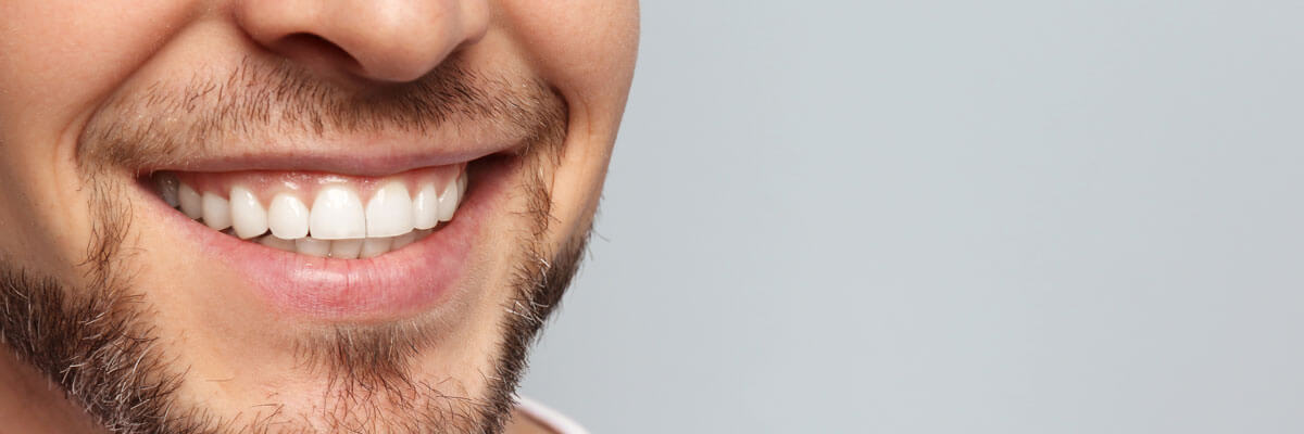 Close-up shot of a smiling man with white teeth