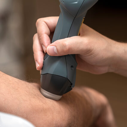 shockwave therapy tool on persons elbow