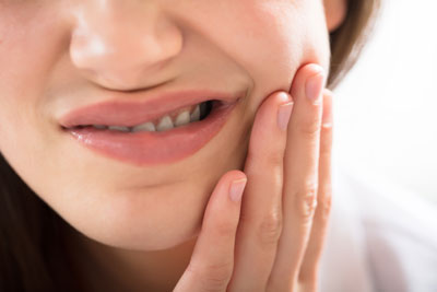 Woman holding mouth in pain