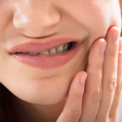 Woman holding her jaw in pain