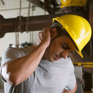 Man in hard hat holding neck