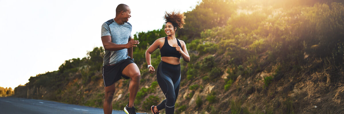 Smiling couple running on a road