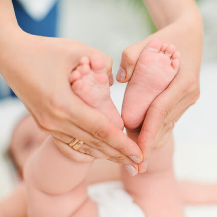 Cute baby feet being held for adjustment