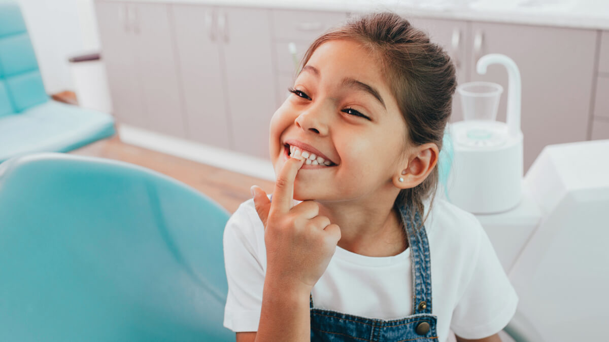 A girl showing her teeth to her dentist.